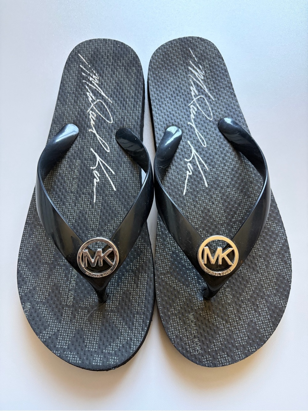 Michael Kors Women’s Black Jet Set Signature Flip Flops with Silver MK Medallion
